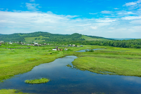 Rural landscape with houses, fields and mountainsの写真素材