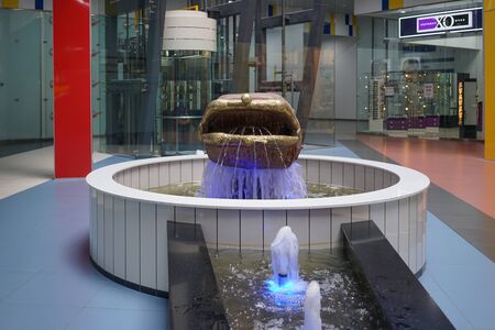 Murmansk, Russia-June 5, 2015: Sculpture in the form of a purse and a fountain with lighting in the shopping center.のeditorial素材