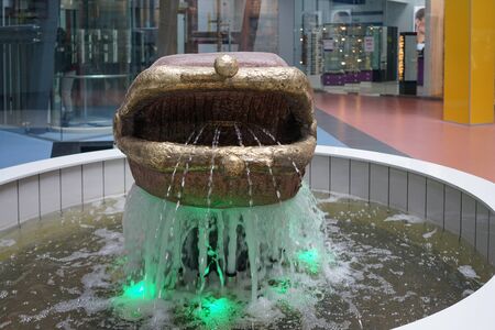 Murmansk, Russia-June 5, 2015: Sculpture in the form of a purse and a fountain with lighting in the shopping center.のeditorial素材