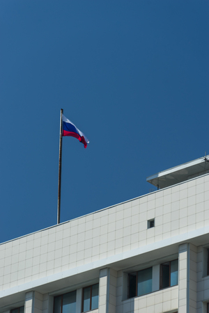 urban landscape with the Russian flag on the building against the blue sky.の写真素材