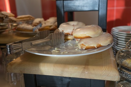 Dish with delicious donuts in the window of the cafe.の写真素材