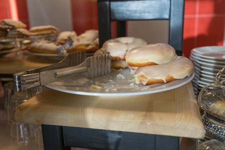 Dish with delicious donuts in the window of the cafe.の写真素材