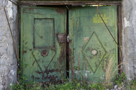 Old rusty metal gate on the background of a gray brick wall.の写真素材