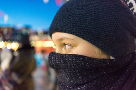 Vladivostok, Russia-January 1, 2019: A young girl with blue eyes wrapped in a dark blue scarf on a...