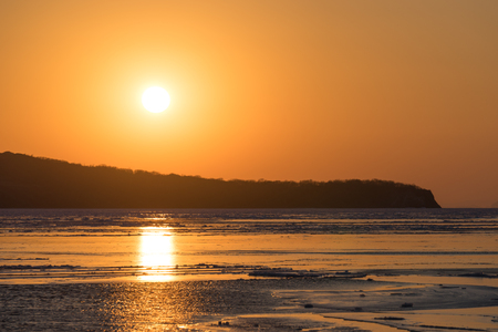 Winter seascape with ice floes on the water surface at sunset. Beauty of nature.の写真素材