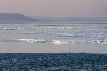 Sea landscape with ice coastline beneath the evening skyの写真素材