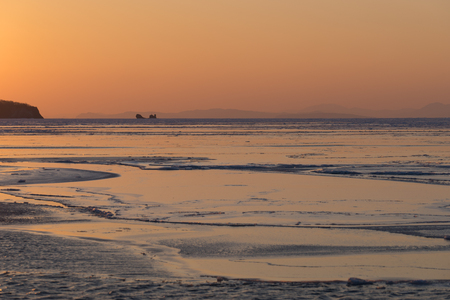 Winter seascape with ice floes on the water surface at sunset. Beauty of nature.の写真素材