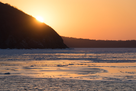 Winter seascape with ice floes on the water surface at sunset. Beauty of nature.の写真素材