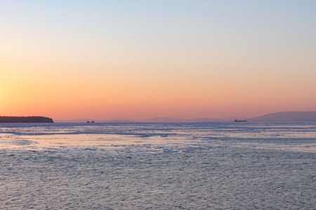 Winter seascape with ice floes on the water surface at sunset. Beauty of nature.の写真素材