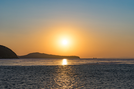 Winter seascape with ice floes on the water surface at sunset. Beauty of nature.の写真素材