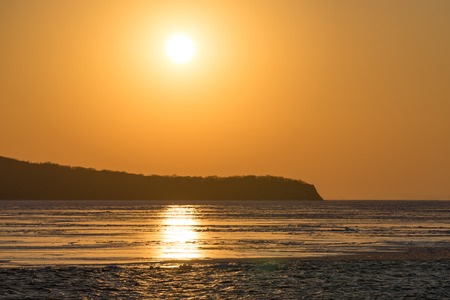 Winter seascape with ice floes on the water surface at sunset. Beauty of nature.の写真素材
