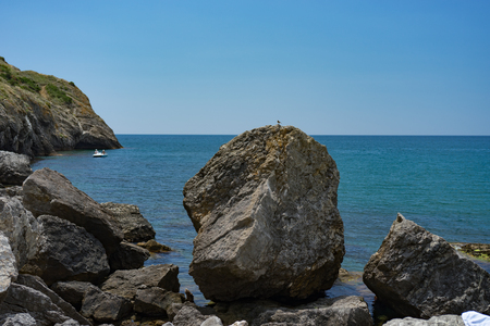 Seascape with a rocky shore line under a blue sky.の写真素材