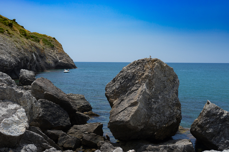 Seascape with a rocky shore line under a blue sky.の写真素材