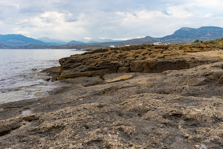 Seascape with a rocky shore line under a blue sky.の写真素材