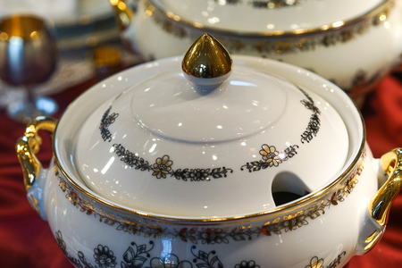 Background with white porcelain tableware with floral ornament and gilded details.の写真素材