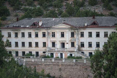 Balaklava, Crimea-June 8, 2016: Destroyed building in Balaklava against the mountainsのeditorial素材