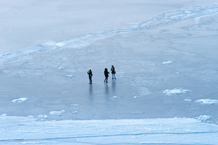White ice surface with silhouettes of people.の写真素材