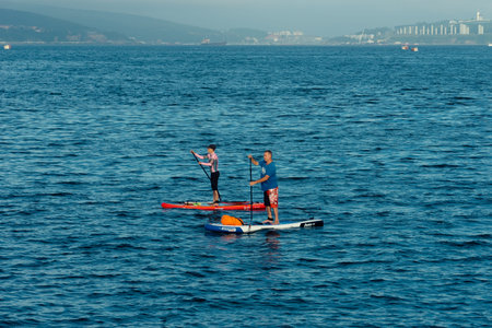Vladivostok, Primorsky Krai-August 26, 2018: People on SUP boards float on the surface of the sea.