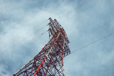 High-voltage tower against the cloudy sky.の写真素材