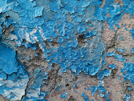 Blue background with cracked oil paint on plaster. For design and networking.の写真素材