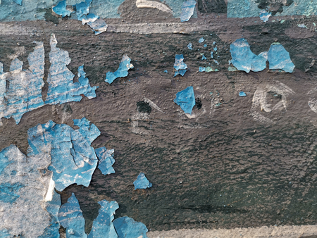 Blue background with cracked oil paint on plaster. For design and networking.の写真素材