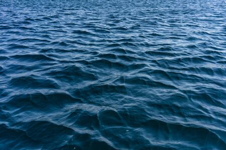 The water surface of the sea is blue with small waves.の写真素材