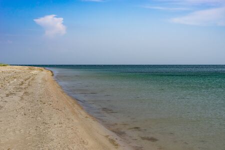 Seascape with sandy beach on the background of the sea.の写真素材