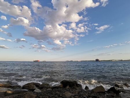 Seascape with ships on the horizon and beautiful white clouds in the sky.の写真素材