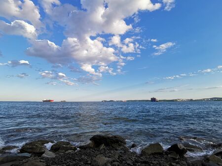 Seascape with ships on the horizon and beautiful white clouds in the sky.の写真素材