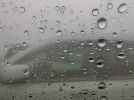 Raindrops on the car window. View of the white car.の写真素材