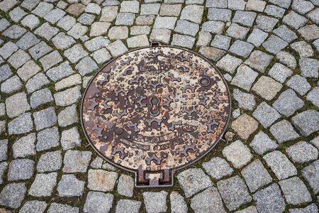 Sewer metal hatch on the background of stone blocks.の写真素材