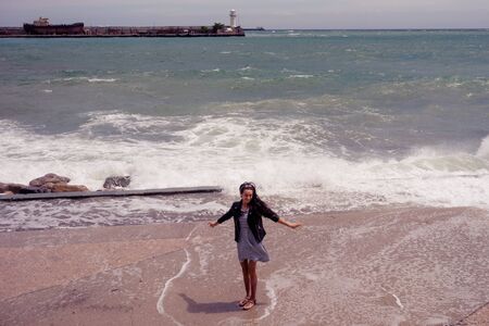 Yalta, Crimea - may 30, 2019: Portrait of a girl on the waterfront of the city against the sea landscape.のeditorial素材