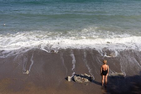 Marine landscape with views of the beach and a woman in a bathing suit.のeditorial素材