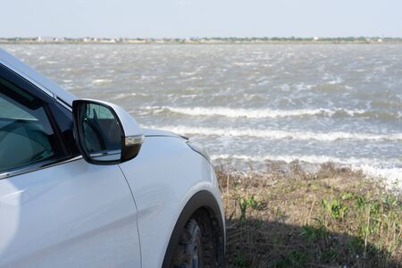 Natural landscape with a white car on the shore of a mud lake.の写真素材