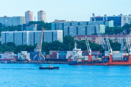 Cityscape with a small boat on the background of the sea. Vladivostok, Russiaのeditorial素材