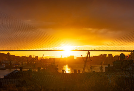Vladivostok, Russia. The city skyline in the sunset light. Silhouettes of the port and the Golden...