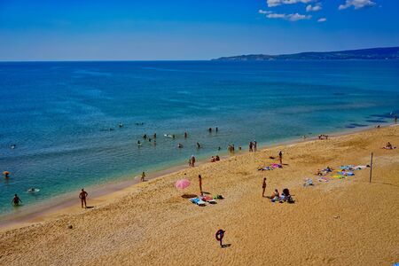 Feodosia, Crimea - June 17, 2016: Seascape with a sandy beach and resting people in the summer.のeditorial素材