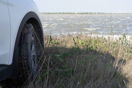 Natural landscape with a white car on the shore of a mud lake. Evpatoria, Crimeaの写真素材