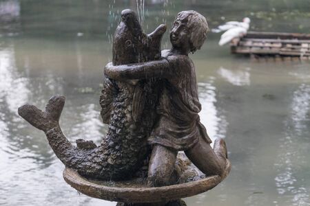 New Athos, Abkhazia-may 9, 2017: Sculpture of a boy with a Dolphin on the background of the pond.のeditorial素材
