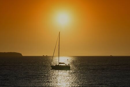 Silhouette of the yacht against the bright orange sunset. Seascape, Vladivostok, Russia.の写真素材