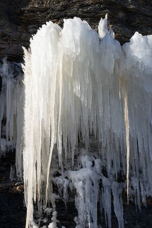 Natural background with icicles on a stone rock.の写真素材