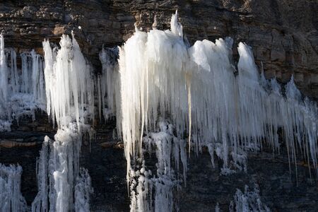 Natural background with icicles on a stone rock.の写真素材