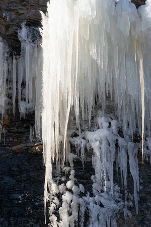 Natural background with icicles on a stone rock.の写真素材