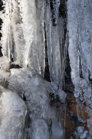 Natural background with icicles on a stone rock.の写真素材