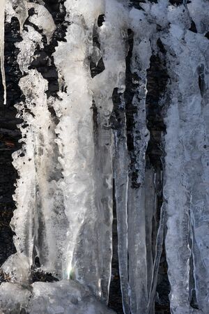 Natural background with icicles on a stone rock.の写真素材