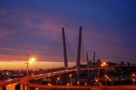 Golden bridge on the background of the magnificent dramatic sky at sunsetの写真素材