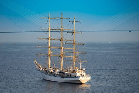 Vladivostok, Primorsky Krai-September 29, 2019: Sailing ship Hope against the sea and the Russian bridge.のeditorial素材