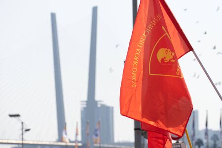 Vladivostok, Primorsky Krai-September 29, 2019: Red flags of the Komsomol organization on the background of the Golden bridge.のeditorial素材