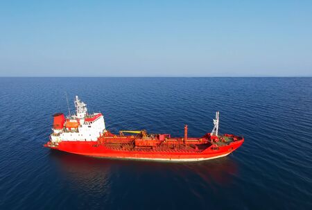 Red ship on the background of seascape and blue skyの写真素材