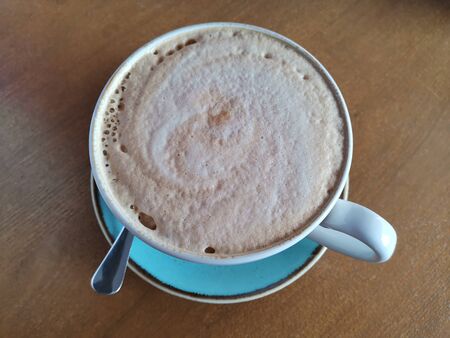 Coffee cup top view on wooden table background.の写真素材